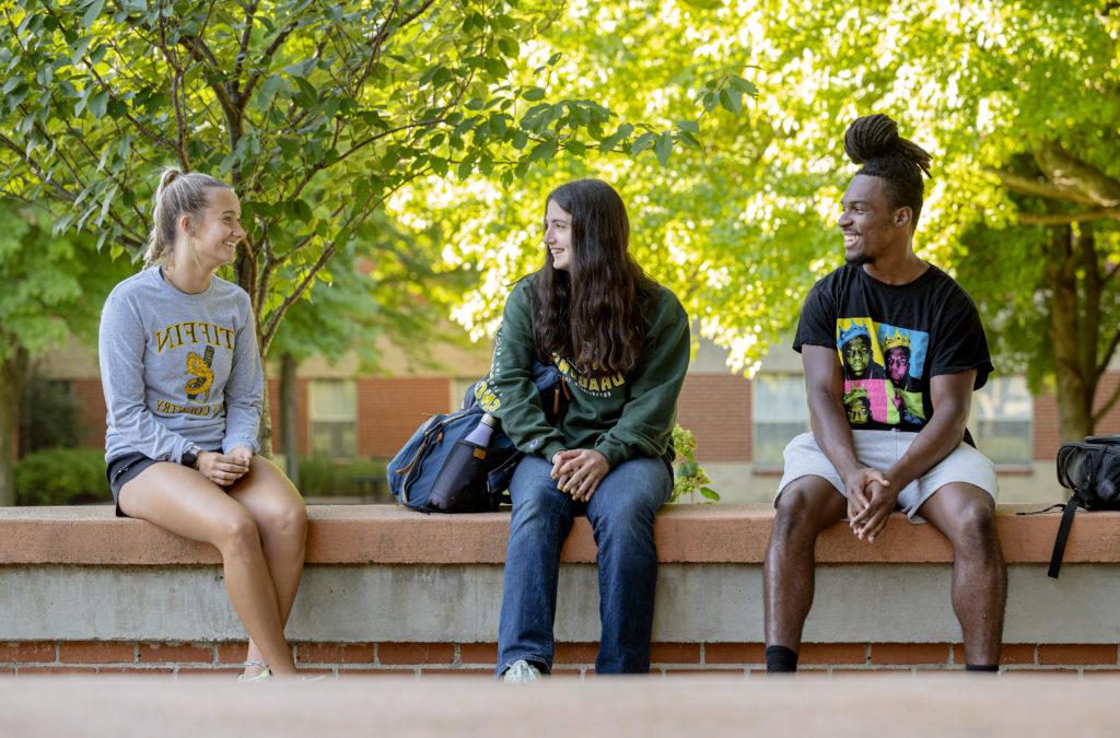 Group of smiling students sitting outside